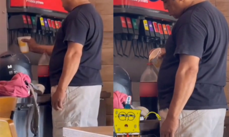 Hombre rellena botella de soda con máquina de restaurante