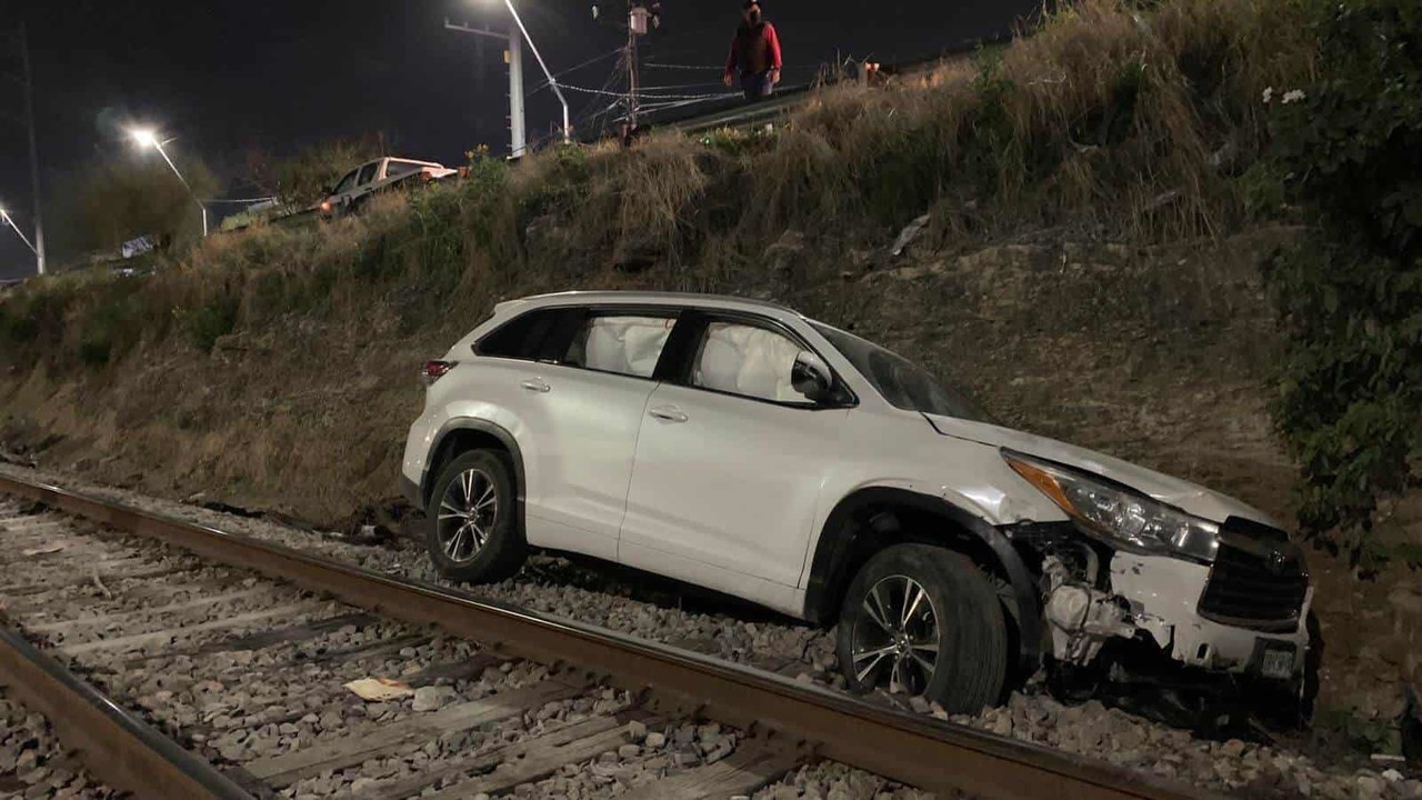 Huye tras chocar su auto que cae sobre las vías del tren