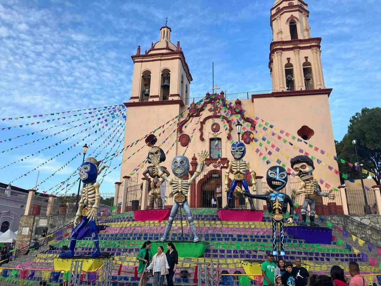Paseantes se toman 'selfie' con luchadores en altar de muertos de Santiago