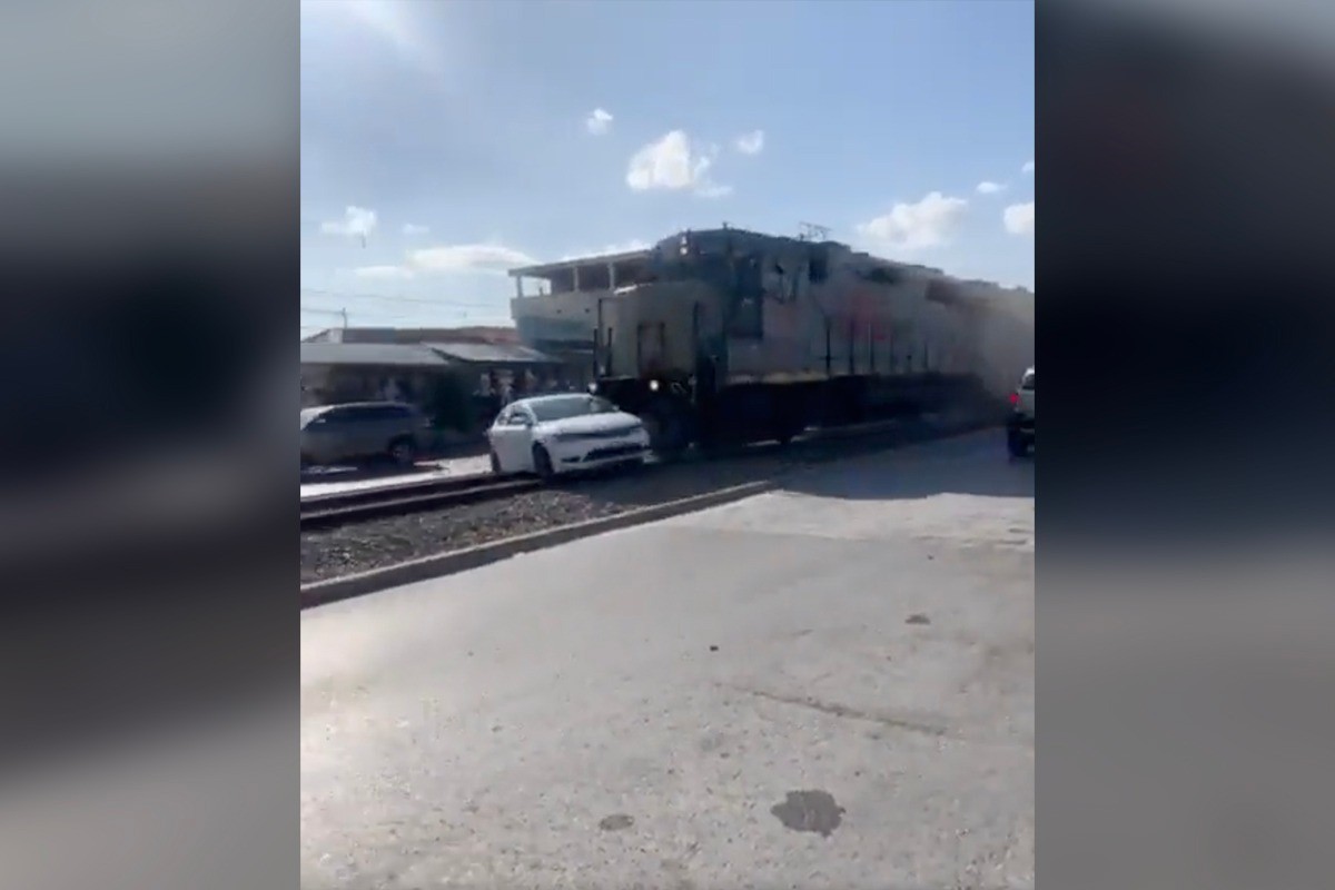 Tren se lleva carro por las vías. FOTO: Captura de Imagen