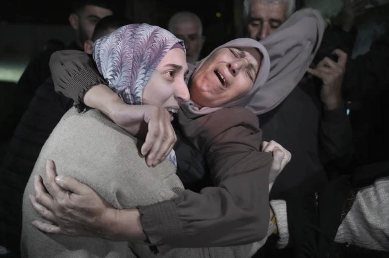 Shuruq Dwayat, a la izquierda, una prisionera palestina liberada por Israel, es abrazada por familiares a su llegada a casa en el vecindario de Sur Bahar, en Jerusalén Oriental, el domingo 26 de noviembre de 2023. (AP Foto/Mahmoud Illean)