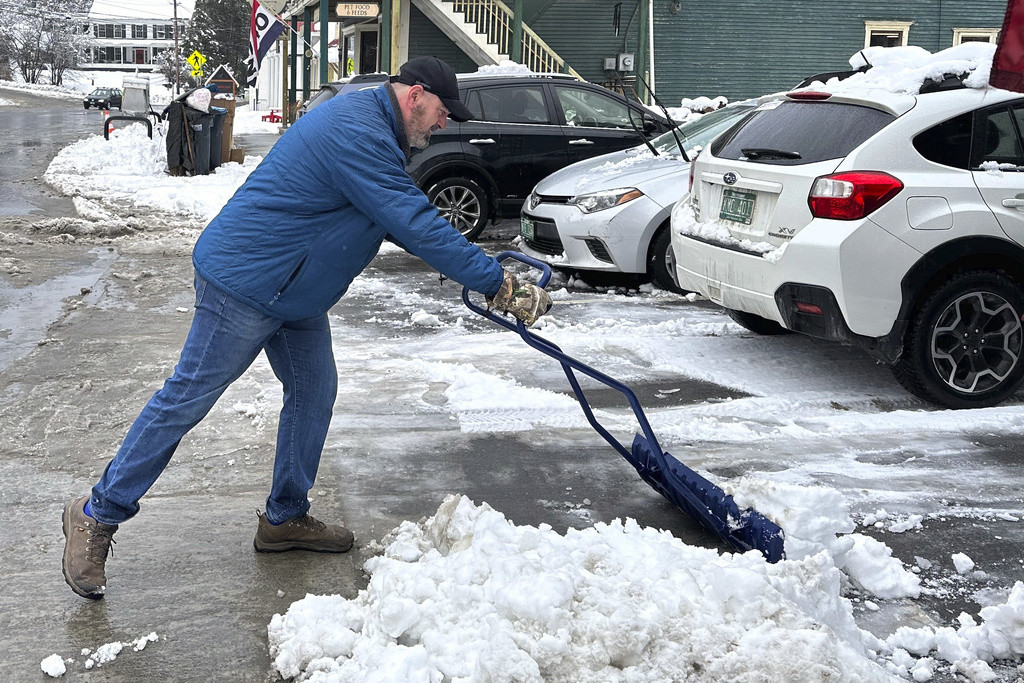 Bobby Searles retira la nieve de un espacio de estacionamiento afuera de la tienda Cabot Village, el lunes 4 de diciembre de 2023, en Cabot, Vermont. (AP Foto/Lisa Rathke)
