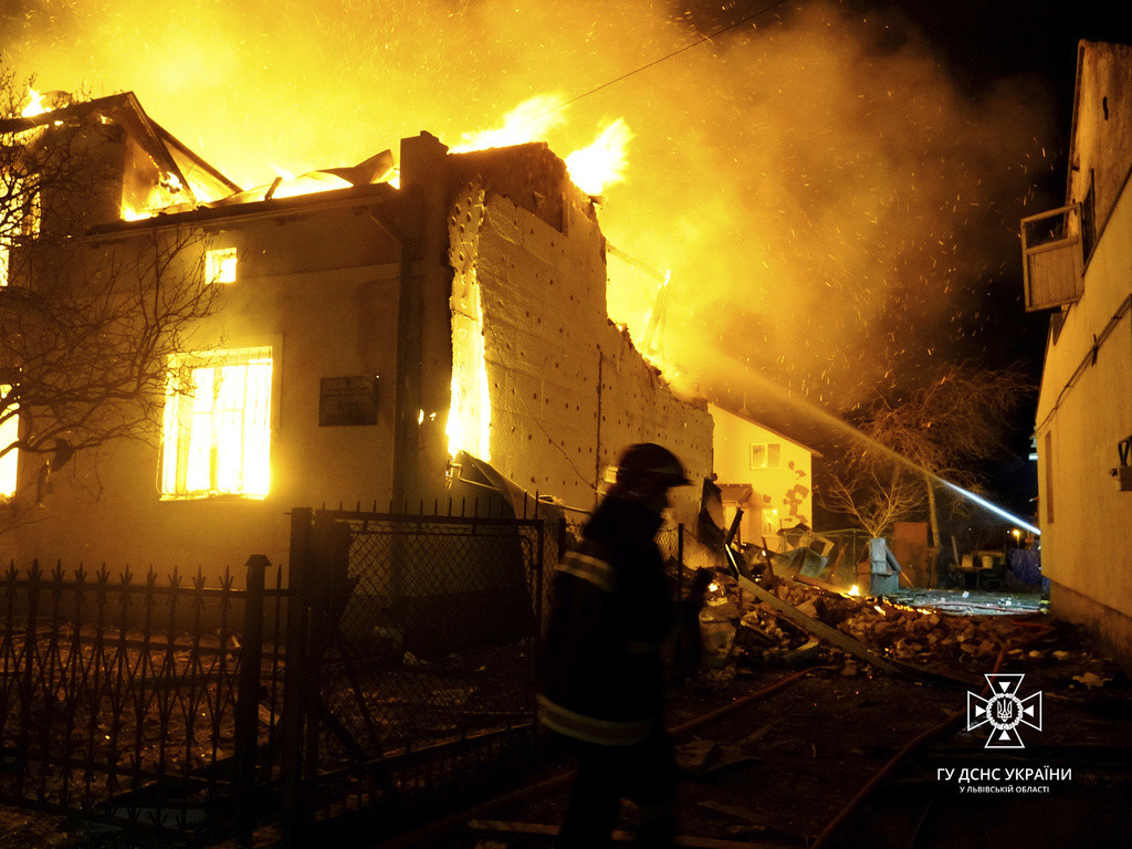 En esta imagen proporcionada por el Servicio de Emergencias de Ucrania, los bomberos trabajan para sofocar un incendio tras un ataque con drones rusos, en Dublyany, en la región de Leópolis, Ucrania, el 1 de enero de 2024. (Servicio de Emergencias de Ucran