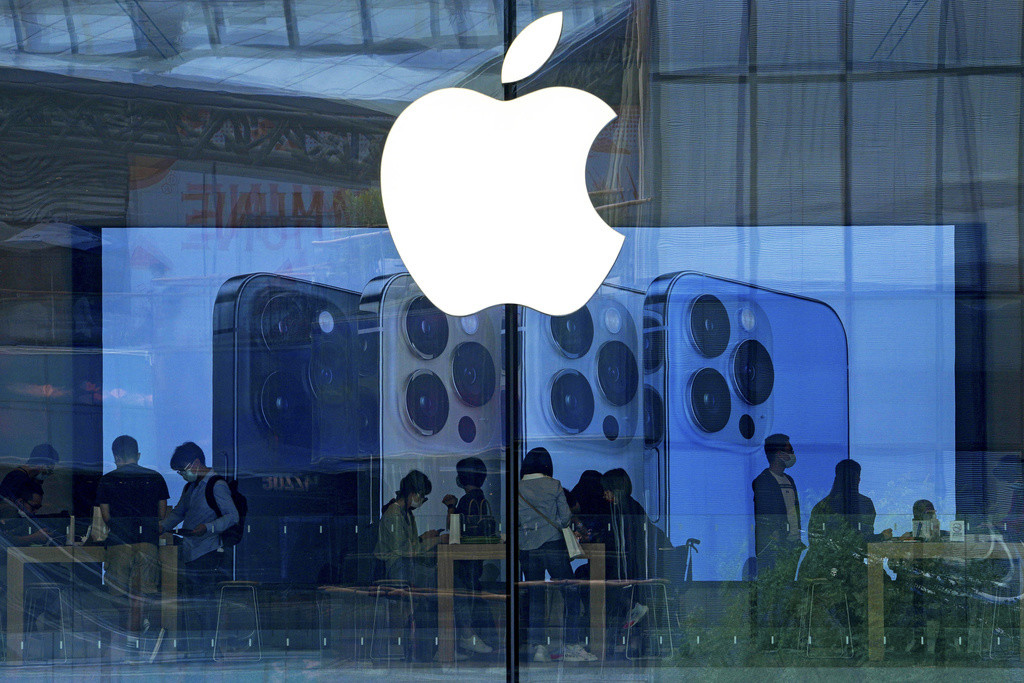 En esta fotografía del 28 de septiembre de 2021, la gente prueba los modelos del iPhone en una tienda de Apple en Beijing. (AP Foto/Andy Wong, Archivo)