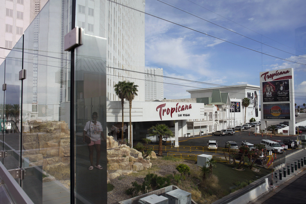 Una persona, reflejada en un vidrio, camina cerca del hotel-casino Tropicana de Las Vegas, el 16 de mayo de 2023. (AP Foto/John Locher, Archivo)