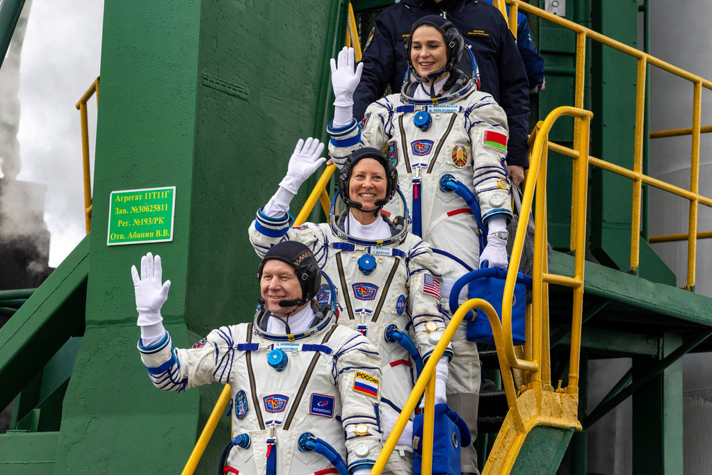 Astronautas saludan al abordar la nave espacial en el cosmódromo Baikonur, arrendado por Rusia, en Kazajstán, el jueves 21 de marzo de 2024. (Corporación espacial Roscosmos vía AP)