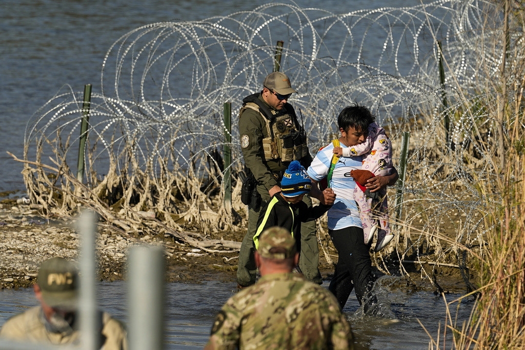 Un grupo de migrantes es detenido por oficiales en la frontera entre Texas y México el 3 de enero de 2024, en Eagle Pass, Texas. (AP Foto/Eric Gay, Archivo)