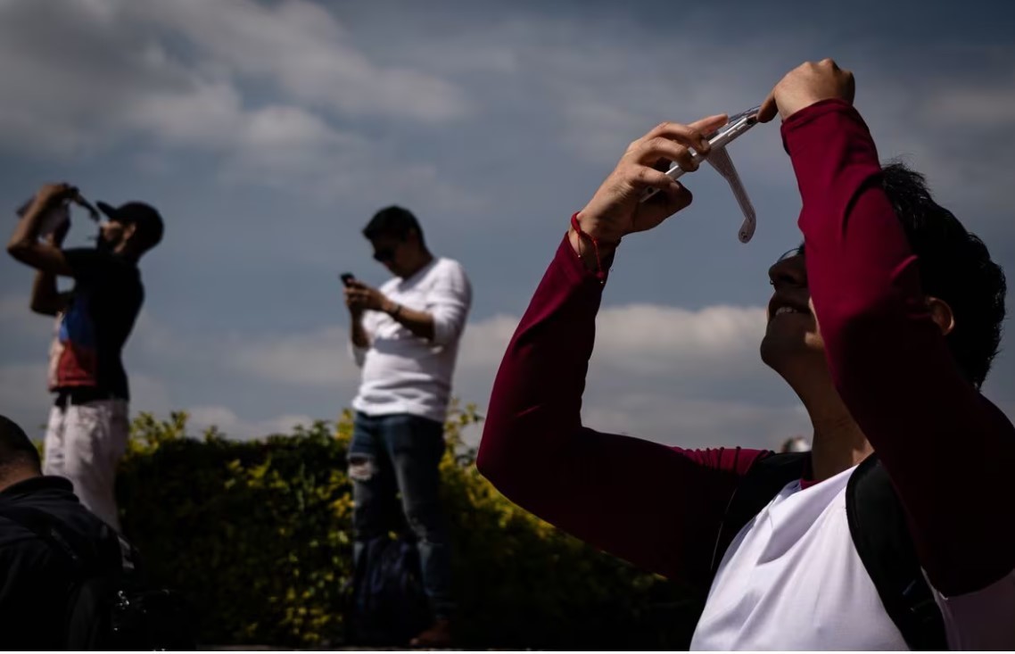 Jóvenes observan un eclipse solar en las islas de Ciudad Universitaria, (2023). Foto. Ilustrativa Nayeli Cruz.