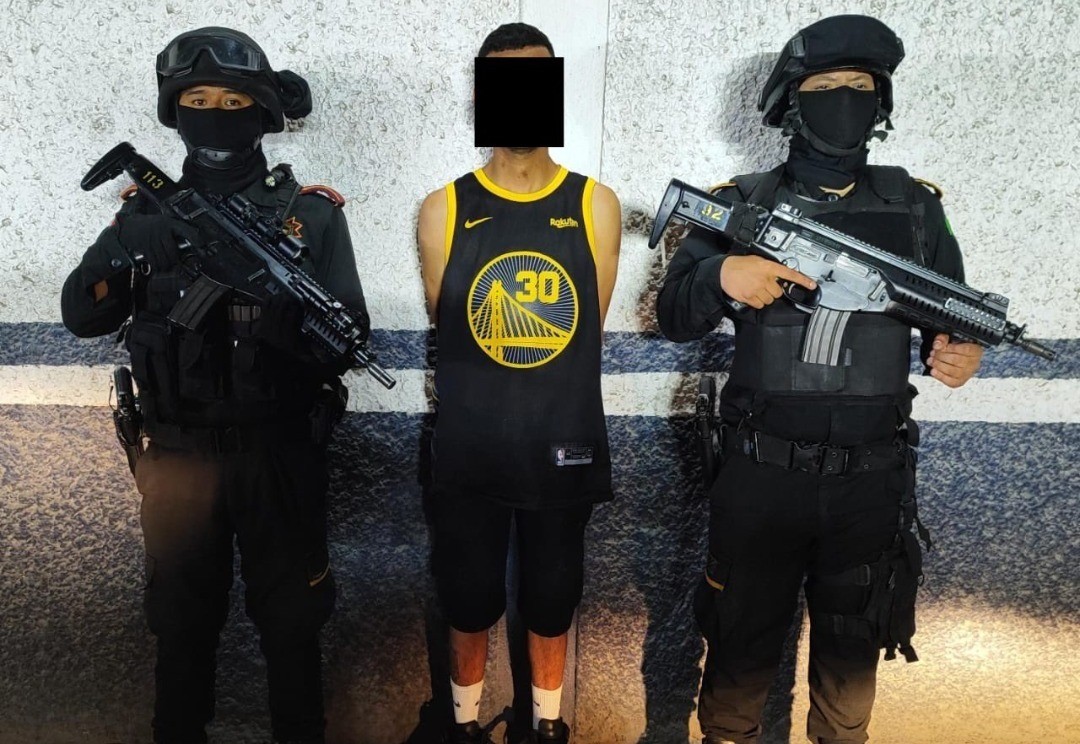 El joven detenido con una playera de básquetbol junto a dos elementos de Fuerza Civil. Foto: X @GpoCoordSegNL.