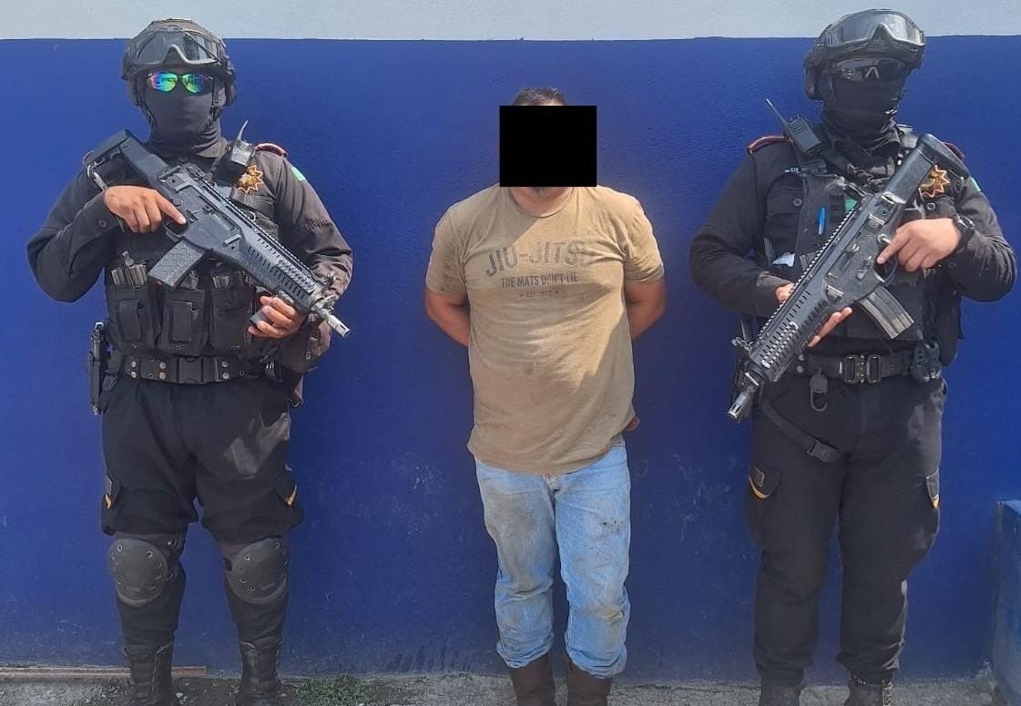 El hombre detenido con dos elementos de Fuerza Civil tras ser aprehendido. Foto: X @GpoCoordSegNL.