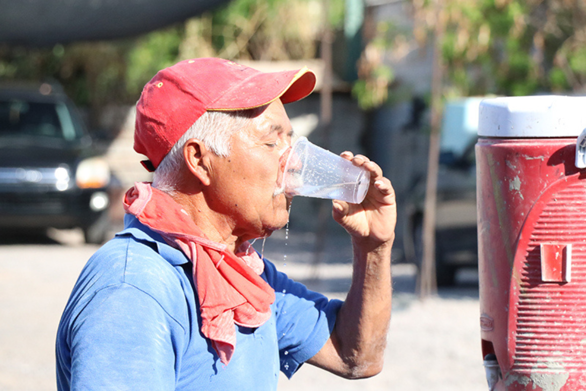 Aldulto mayor tomando agua para evitar un golpe de calor. Foto: Gobierno de BCS