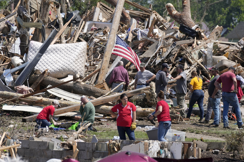 Residentes retiran los escombros de una casa dañada por un tornado, el miércoles 22 de mayo de 2024 en Greenfield, Iowa. (AP Foto/Charlie Neibergall)