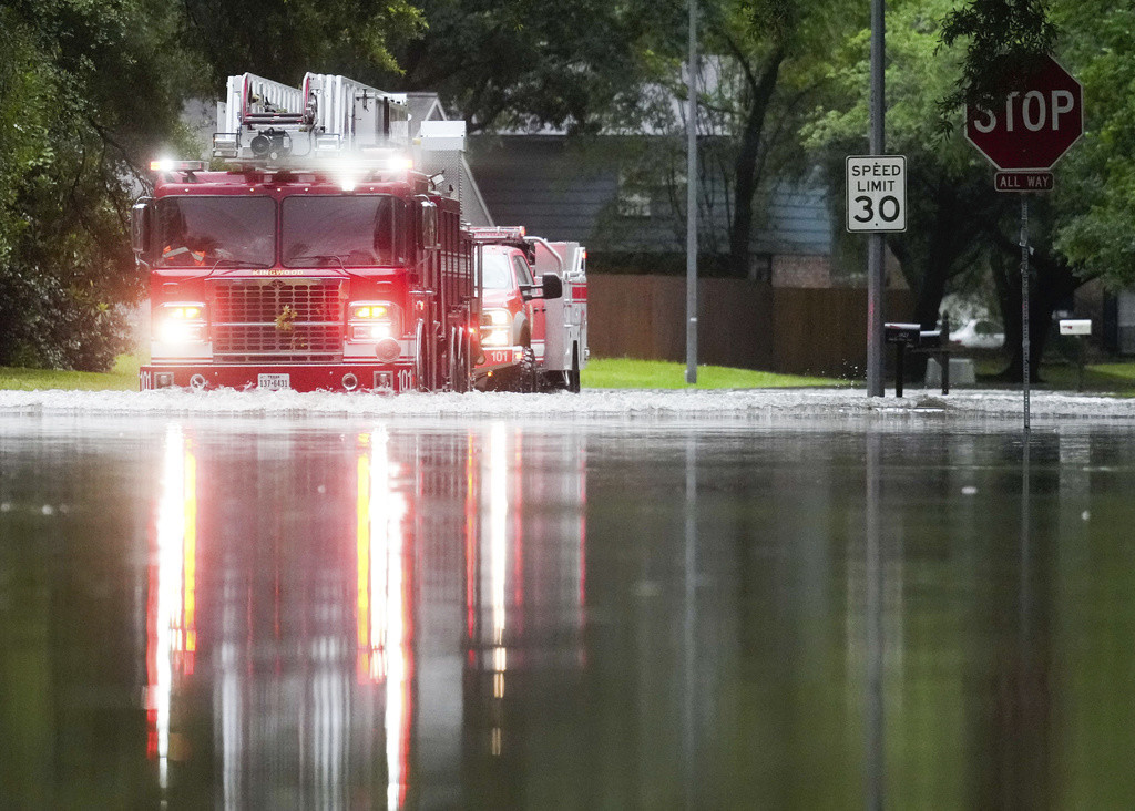 Un camión de bomberos de Houston atraviesa un camino inundado en North Woodland Hills luego de unas lluvias torrenciales, el jueves 2 de mayo de 2024, en el vecindario de Kingwood, en Houston, Texas. (Jason Fochtman/Houston Chronicle via AP)