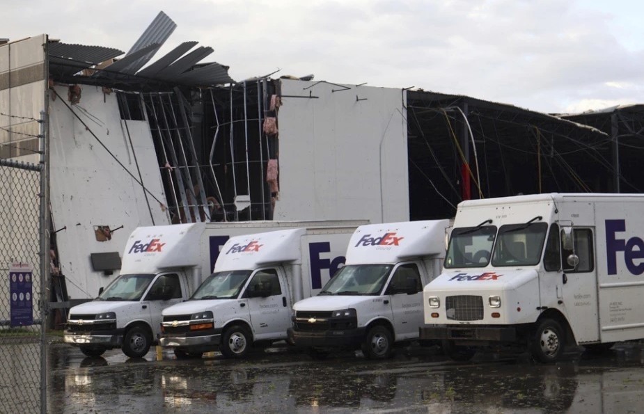 Camiones de FedEx se ven ante un centro dañado de FedEx tras el paso de un tornado en Portage, Michigan. (Brad Devereaux/Kalamazoo Gazette via AP)