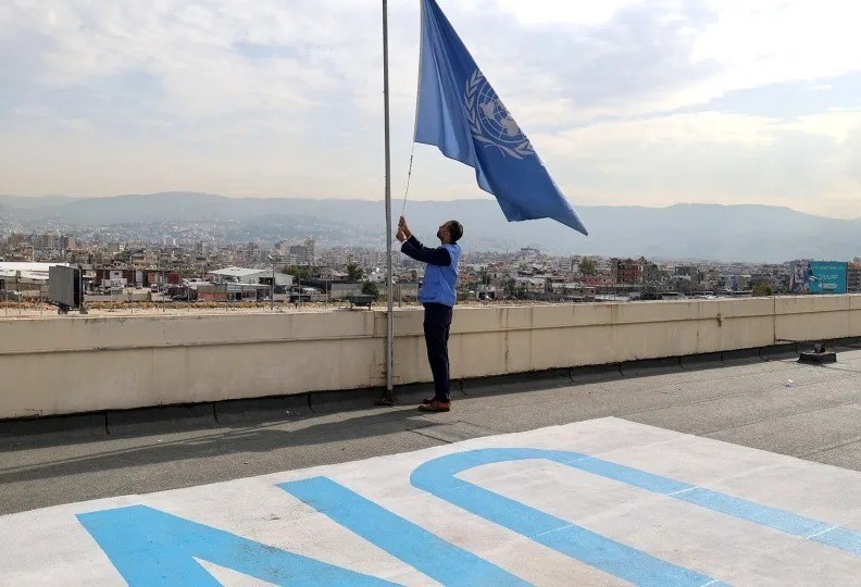 Un soldado de la ONU pone la bandera a media asta en honor a su compañero caído. Foto: CNN Español.