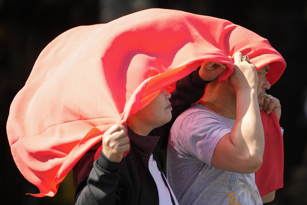 Un hombre y una mujer se cubren la cabeza con un mantel para protegerse del sol en Manila, Filipinas, el 29 de abril de 2024. (AP Foto/Aaron Favila, Archivo)