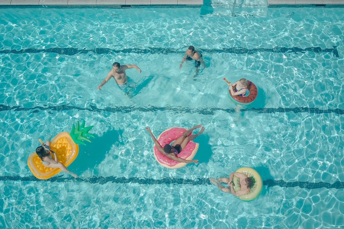 Seis personas disfrutando de una tarde en la piscina. Foto: Canva