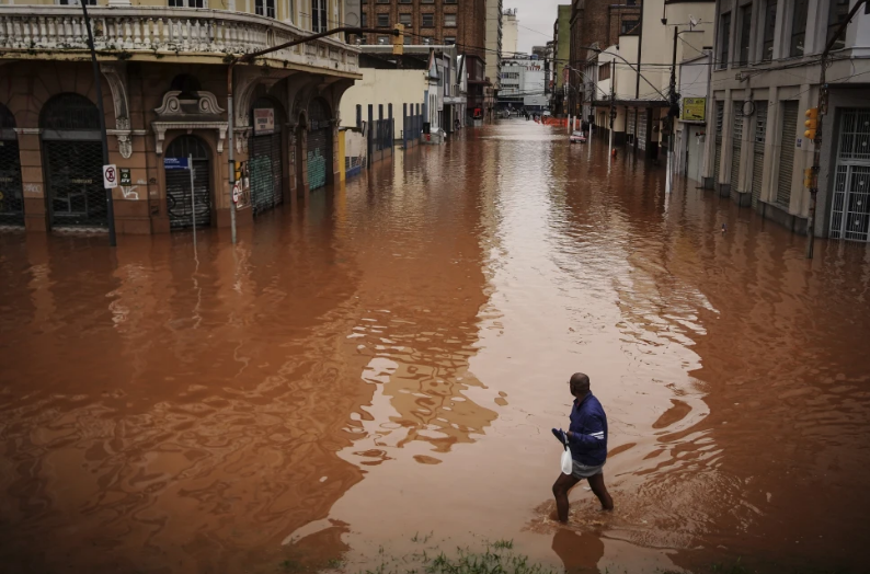 Un hombre camina por una calle inundada debido a las intensas lluvias, el viernes 3 de mayo de 2024, en Porto Alegre, estado de Río Grande do Sul, Brasil. (AP Foto/Carlos Macedo)