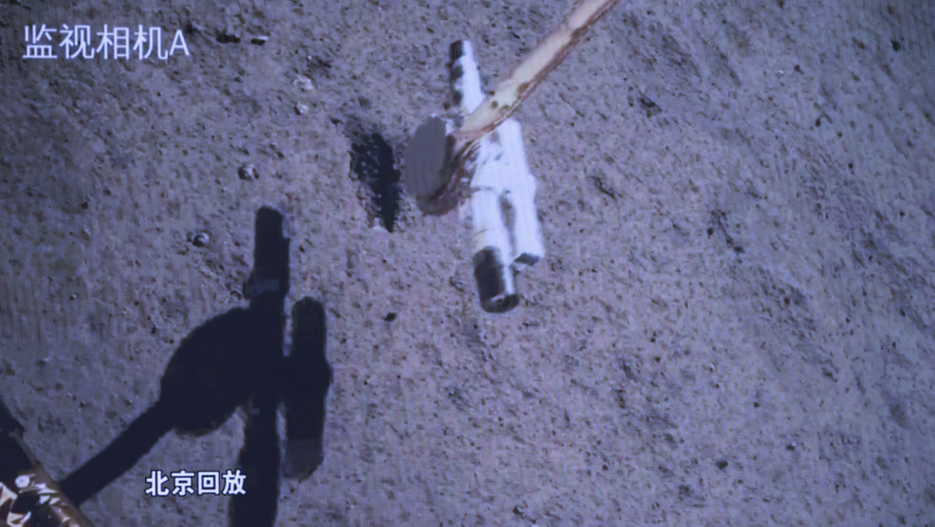En esta foto distribuida por la agencia de noticias Xinhua, una pantalla del Centro de Control Aeroespacial de Beijing muestra a la sonda Chang'e-6 recolectando muestras de la superficie lunar, el martes 4 de junio de 2024. (Jin Liwang/Xinhua vía AP)