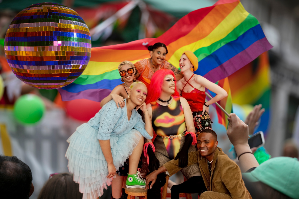 Bandera LGBT, bola de disco y personas de la comunidad. Foto: Canva