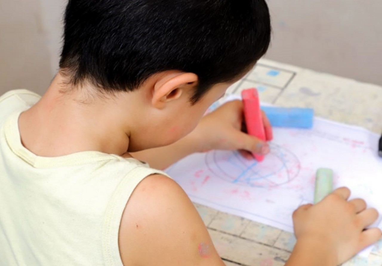 Un alumno con el TEA haciendo un dibujo en una escuela. Foto: TVN.