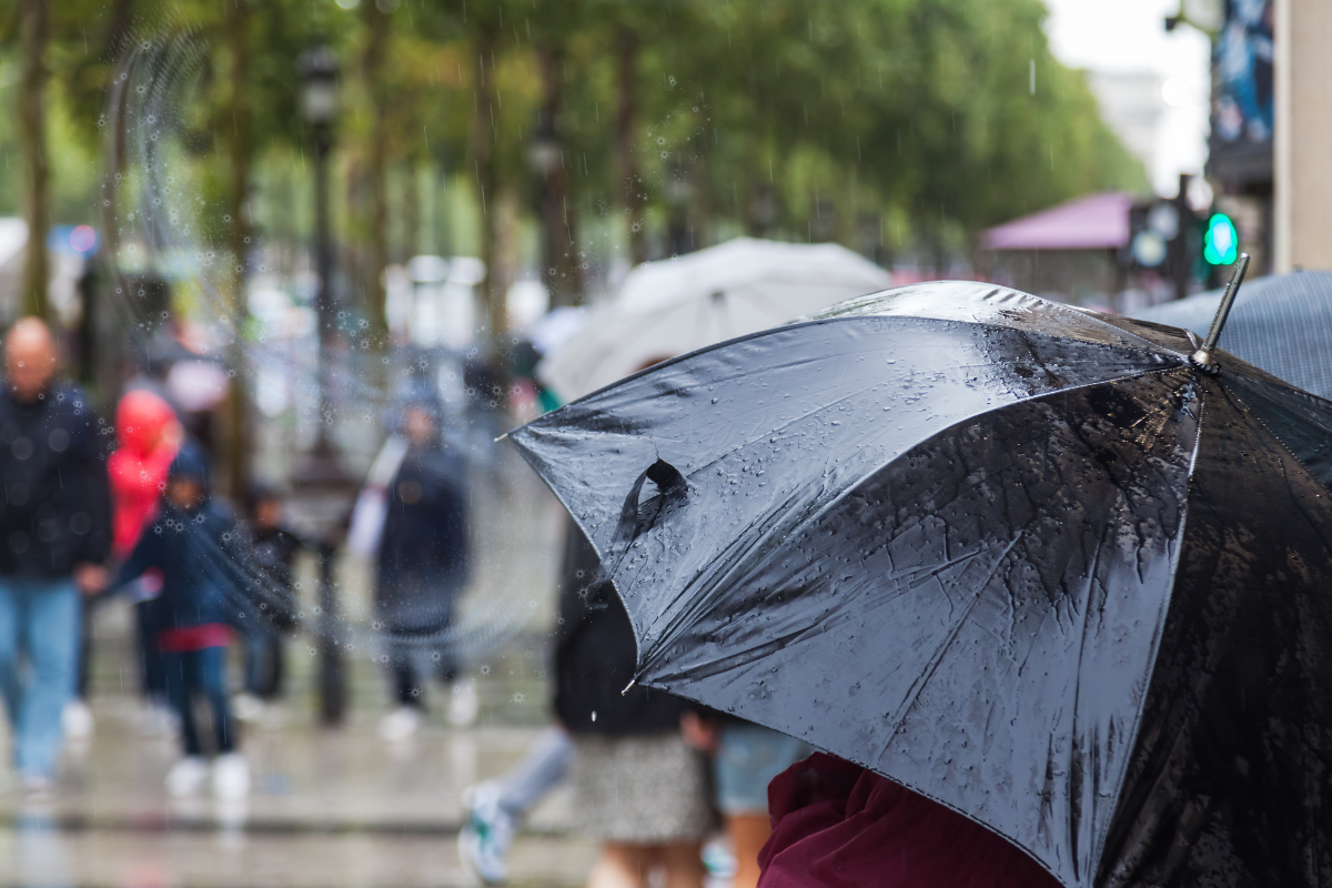 Persona con sombrilla para las lluvias. Foto: Canva