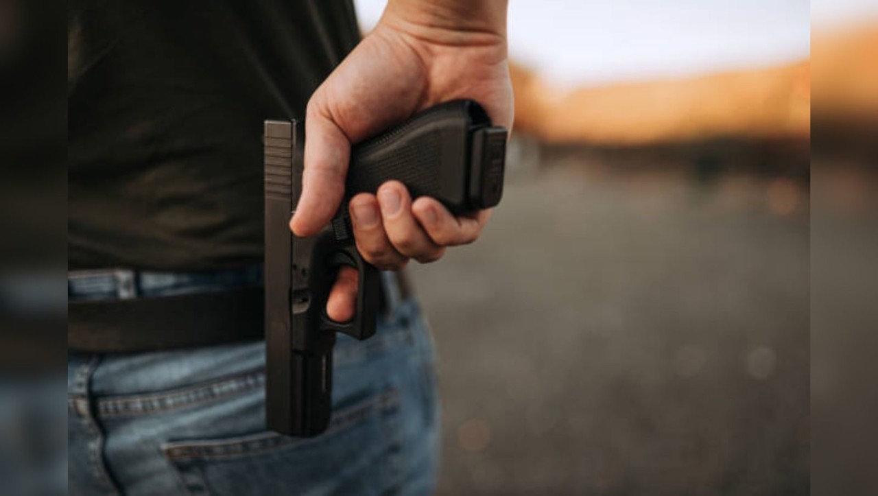 Un hombre portando un arma de fuego en su espalda. Foto: Pixabay.
