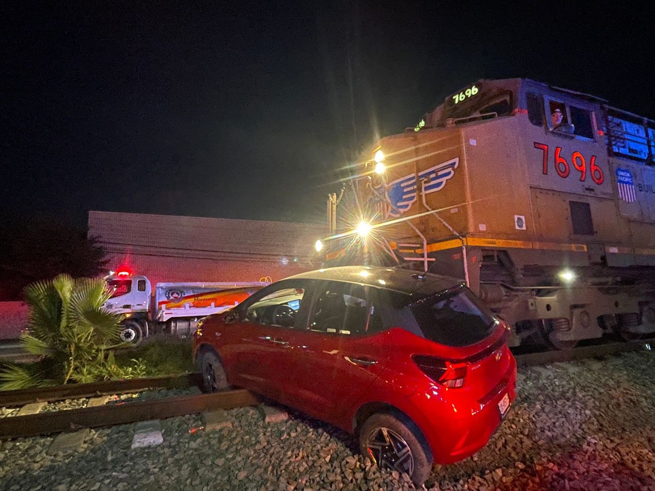 Vehículo color rojo impactado por un tren. Foto: Azael Valdés