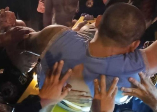 El hombre siendo auxiliado por sus vecinos después de quedar ensartado en una reja divisoria. Foto: Yahoo Noticias.