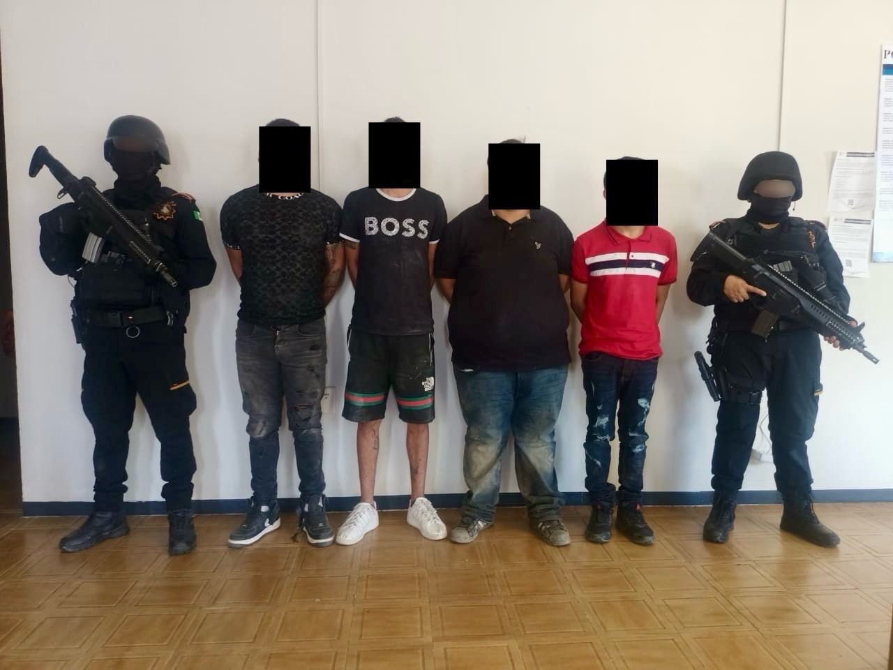 Cuatro hombres detenidos con armas junto a elementos de Fuerza Civil. Foto: Secretaría de Seguridad Nuevo León