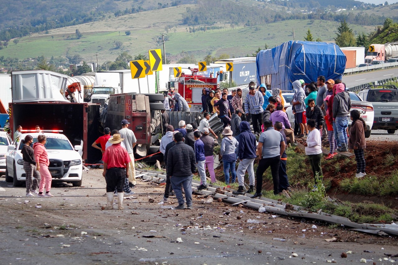 Personas acercándose al trailer que se volcó. Foto: Especial