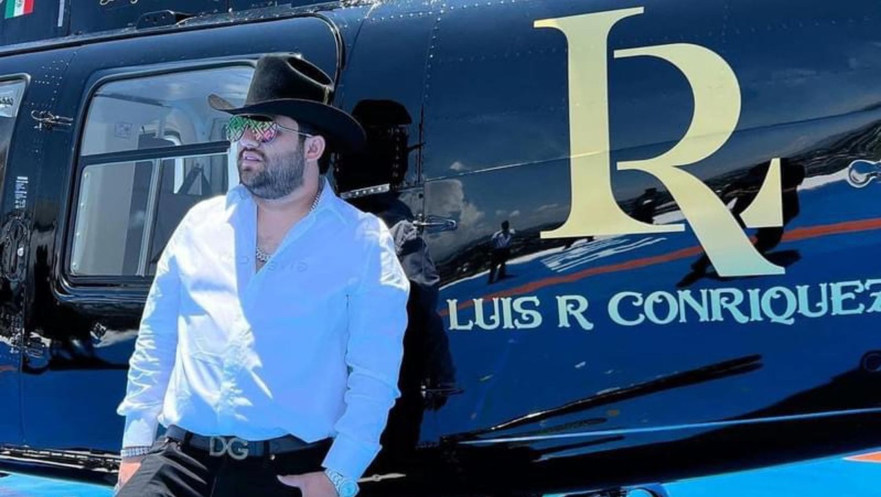 Luis R Conriquez posando junto a un helicóptero que porta su logo. Foto: Facebook Luis R Conriquez.