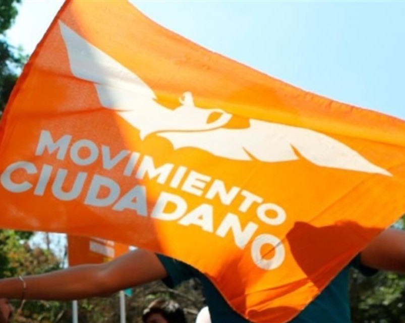 Bandera de Movimiento Ciudadano siendo puesta en una casa durante una campaña. Foto: Facebook Movimiento Ciudadano.