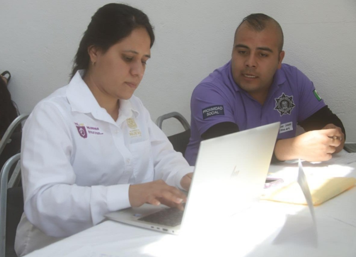 Personal de la Secretaría de las Mujeres de Nuevo León y un policía municipal revisando los temas en las mesas 'Somos tu red de apoyo'. Foto: Facebook Gobierno de García.