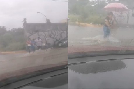 Personas arriesgan su vida para cruzar avenida inundada (VIDEO)