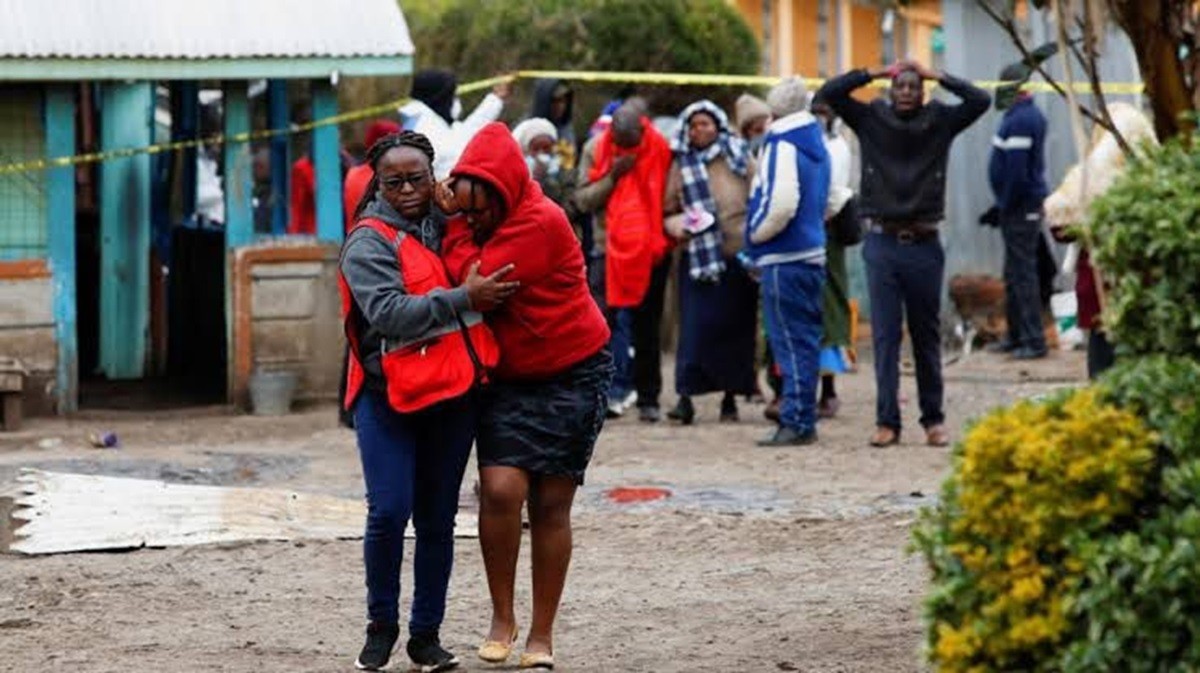 familiares de víctimas del incendio en escuela en Kenia permanecen en el lugar de los hechos esperando noticias.