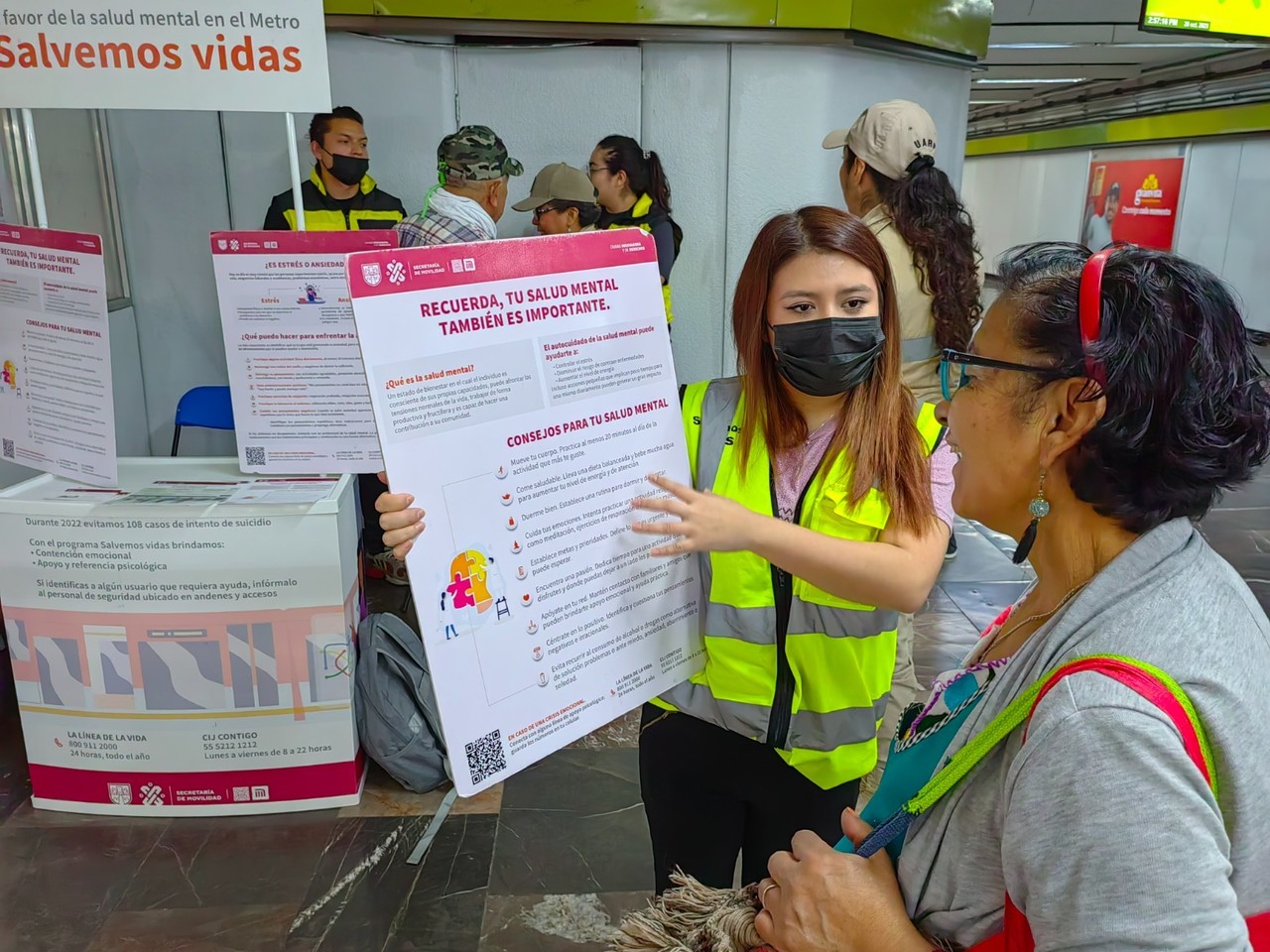 Personal del Metro con capitalina hablando del programa 'Salvemos Vidas'. Foto: @MetroCDMX