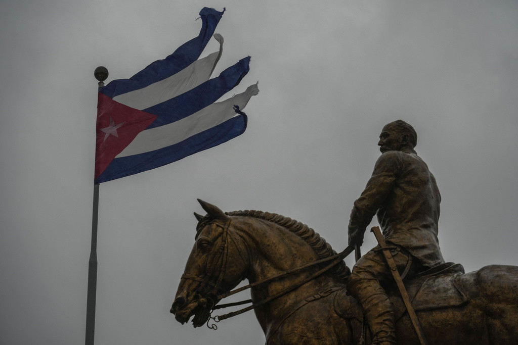 Una bandera cubana destrozada por los vientos del huracán Rafael ondea sobre la estatua del general Calixto García en La Habana, Cuba, el miércoles 6 de noviembre de 2024. (Foto AP/Ramón Espinosa)