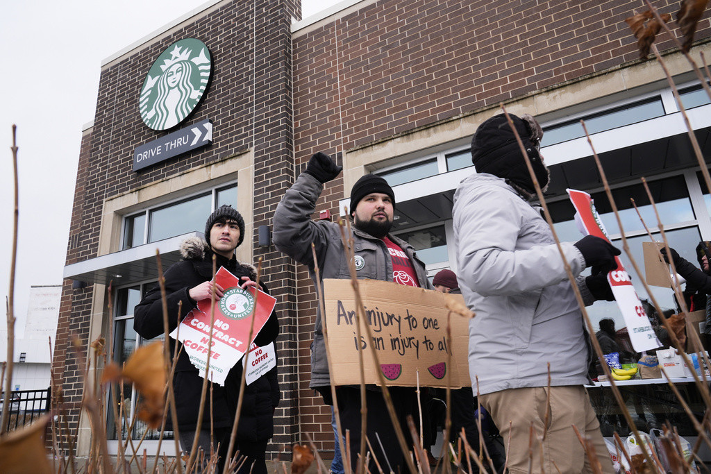 Un grupo de empleados fuera de un local de Starbucks, el viernes 20 de diciembre de 2024, en Chicago. (AP Foto/Kiichiro Sato)