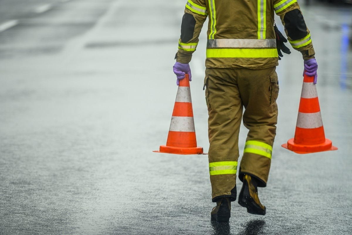 Hombre con conos de precaución. Foto: Canva