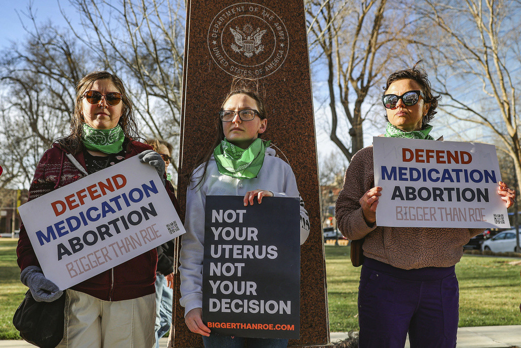 Tres miembros del grupo Women's March protestan en apoyo al acceso a la píldora abortiva frente al Tribunal Federal el miércoles 15 de marzo de 2023 en Amarillo, Texas. (Foto AP/David Erickson, Archivo)