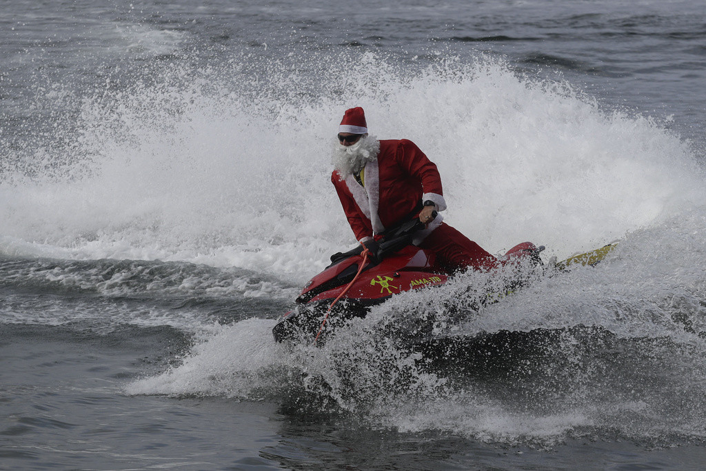 Un bombero disfrazado de Santa Claus en un jet ski por la playa de Copacabana, el martes 17 de diciembre de 2024, en Río de Janeiro. (AP Foto/Bruna Prado)