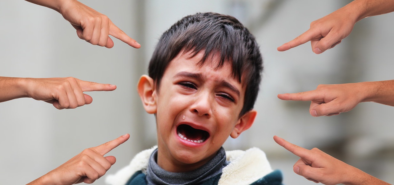 Foto de niño llorando siendo señalado por varias manos a su al rededor. Imagen ilustrativa de maltrato y/o bullying. Créditos: www.pixabay.com (imagen ilustrativa)