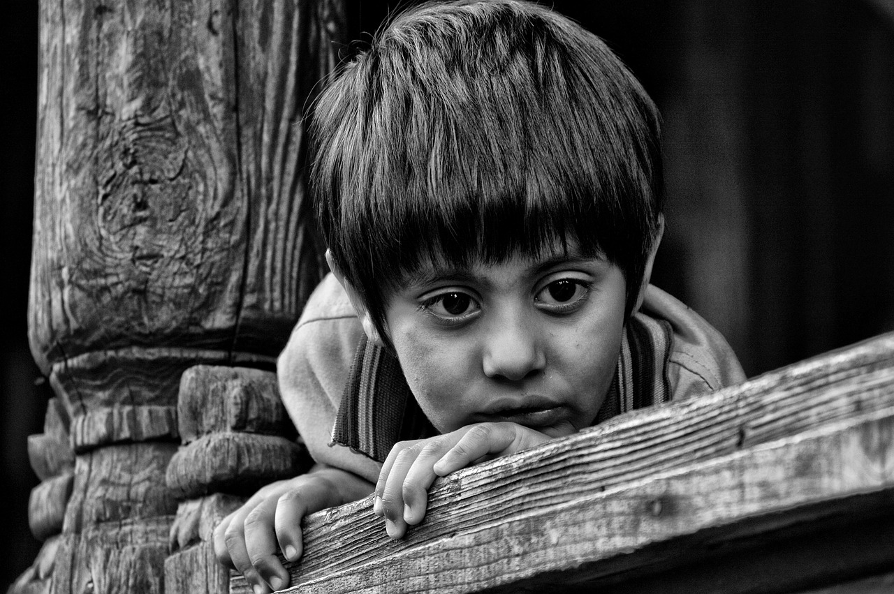 imagen de niño indígena triste, observando oculto tras un marco de madera. Foto: pixabay.com (imagen ilustrativa). 