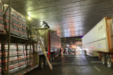 Tráiler cargado de refrescos, se atora bajo un puente por exceder altura permitida