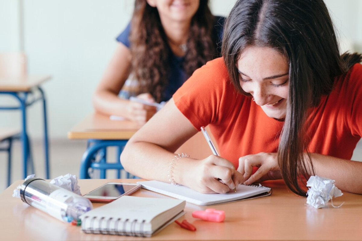 Estudiantes en salón de clases anotando en sus cuadernos.     Foto: Freepik