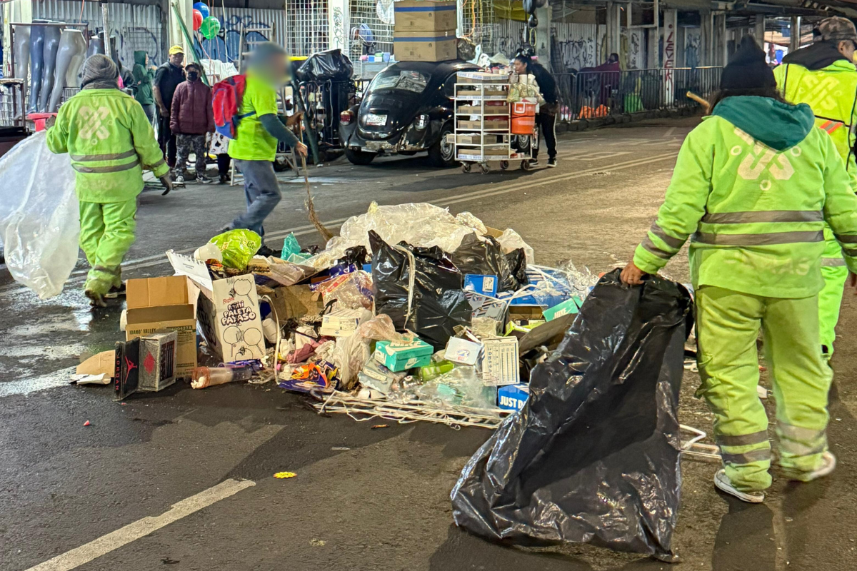 Trabajadores de limpieza de CDMX, retirando puestos de la romería de Eje 1 Norte.    Foto: Ramón Ramírez