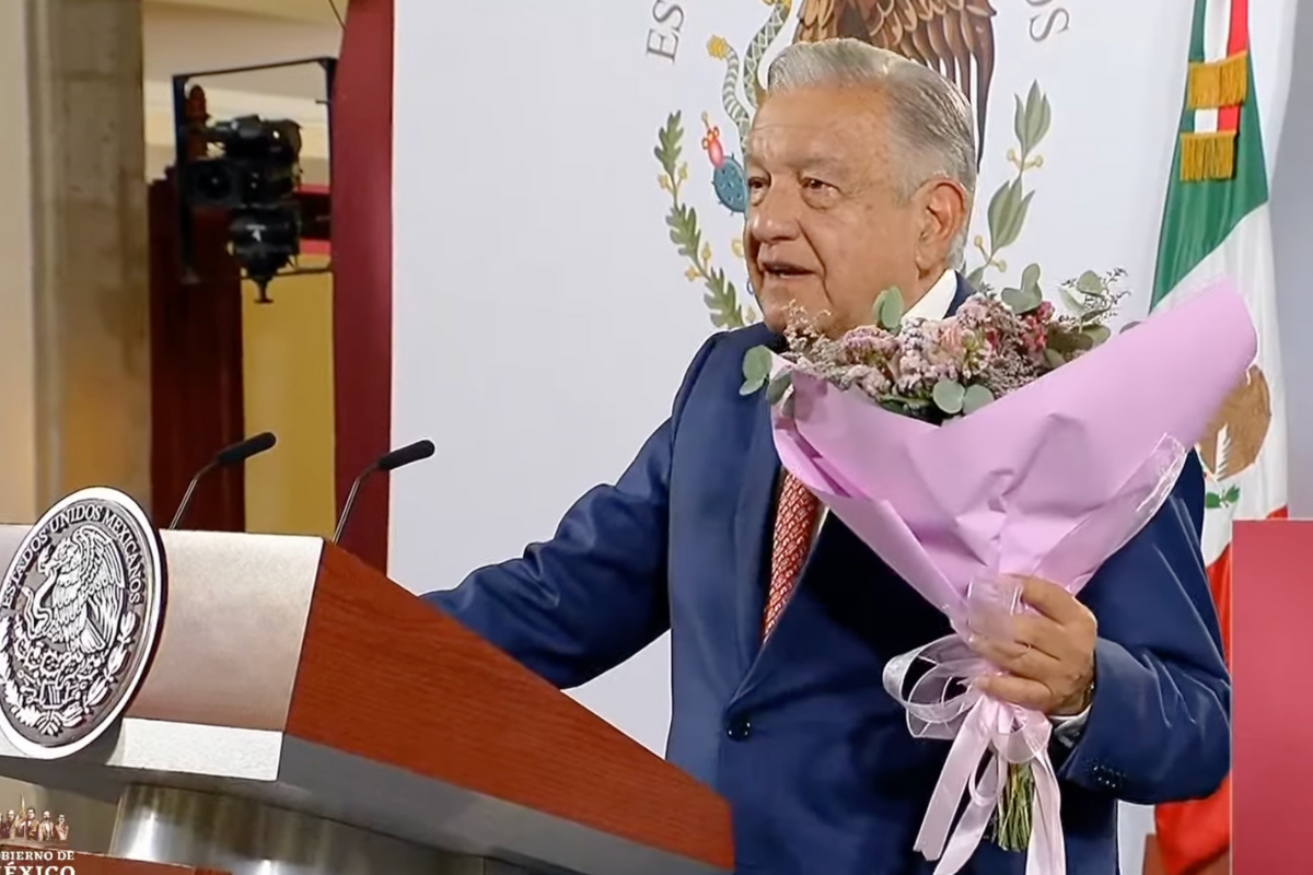 El presidente AMLO en conferencia del 10 de mayo de 2024, portando un ramo de flores. Captura de pantalla/YouTube