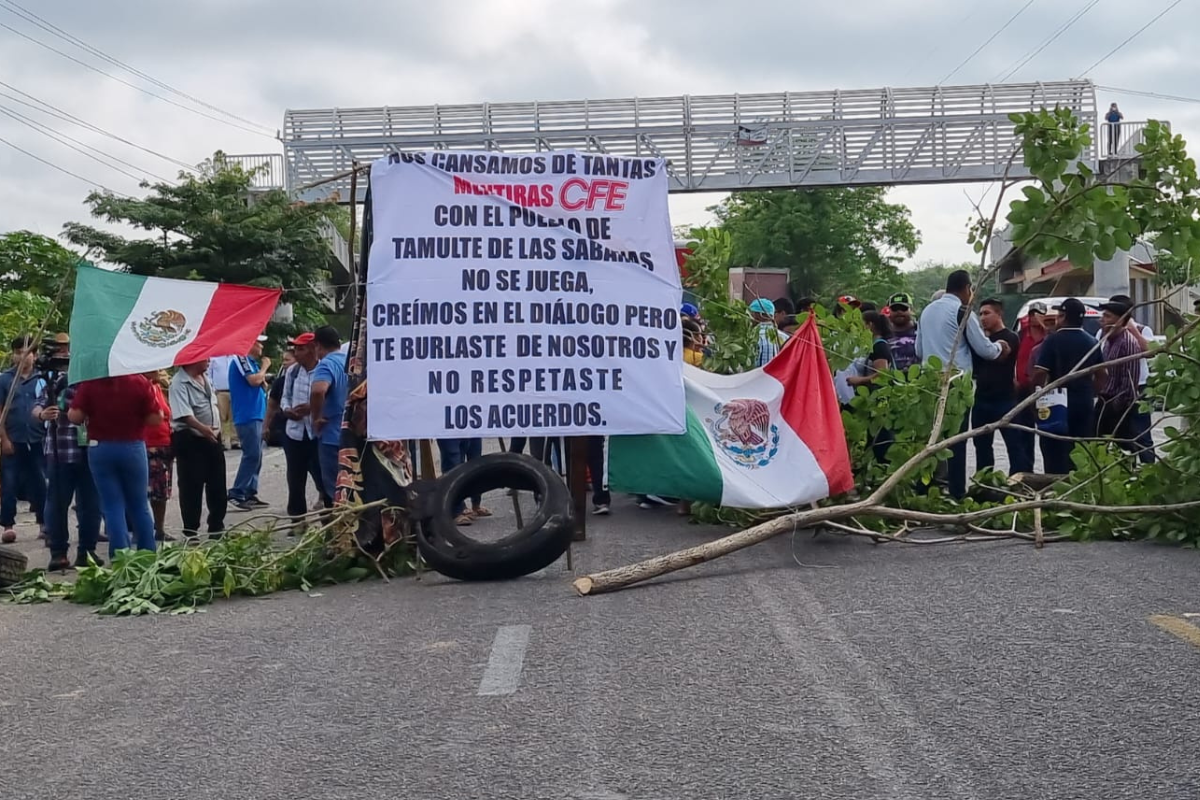 Manifestantes en su bloqueo de la carretera Villahermosa-Frontera y la pancarta donde expresan su postura.Foto: Armando de la Rosa