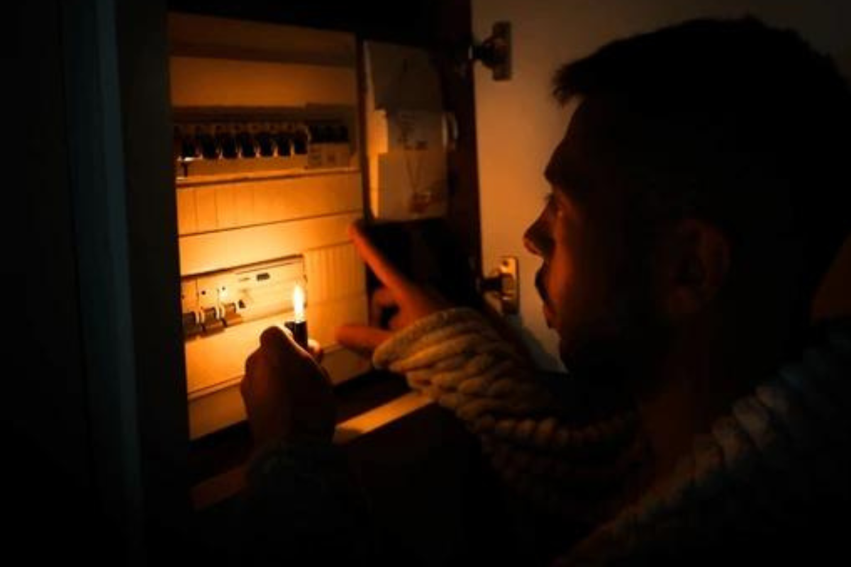 Hombre revisando toma de luz con un encendedor. Foto: Especial